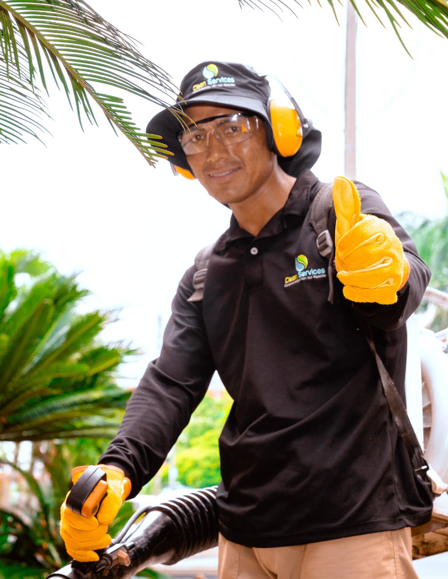Especialista podando y manteniendo las plantas de un jardín vertical modular instalado en una fachada corporativa o residencial.