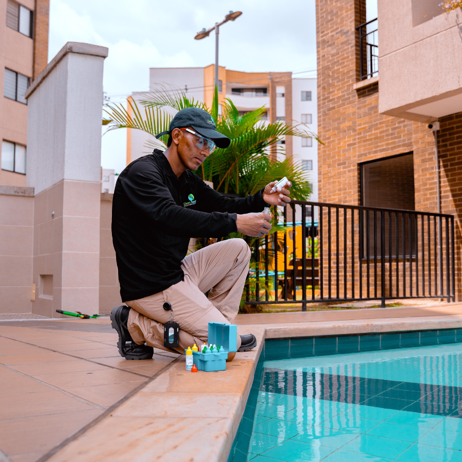 Técnico de Clean Services aspirando y controlando los niveles de pH y cloro en una piscina comunal de un conjunto residencial en Cali.