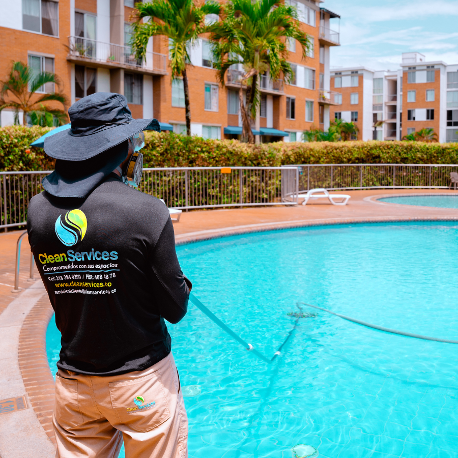 Técnico de Clean Services aspirando y controlando los niveles de pH en una piscina comunal de un conjunto residencial en Cali.